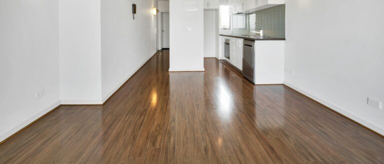 Empty kitchen room with laminate flooring and white walls
